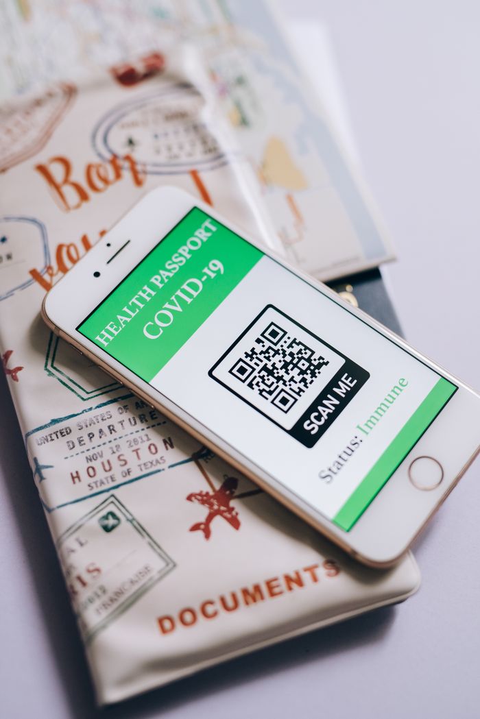 Smartphone displaying a COVID-19 health passport with QR code, indicating immunization status.